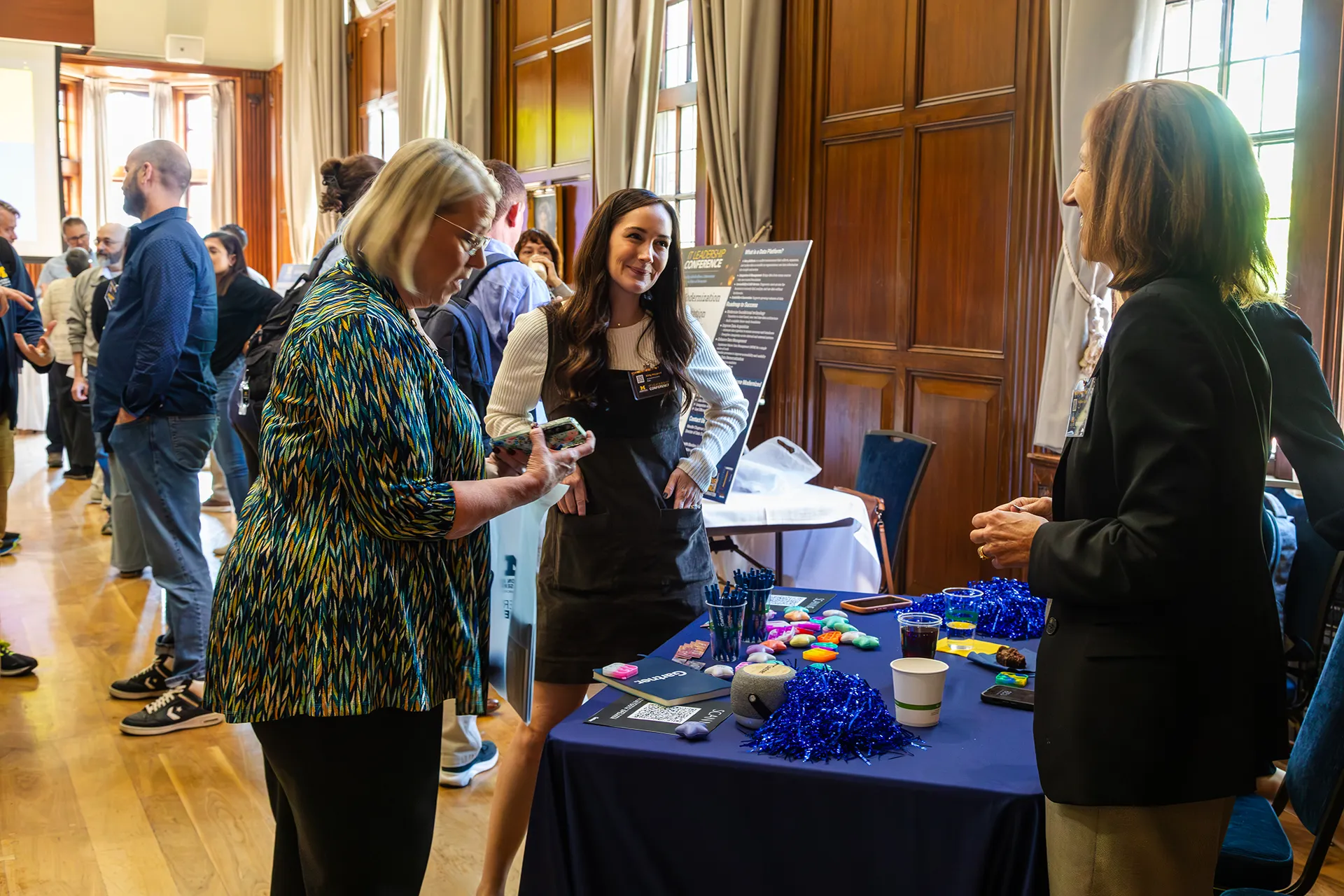 Conference attendees standing around a table in discussion during poster presentations