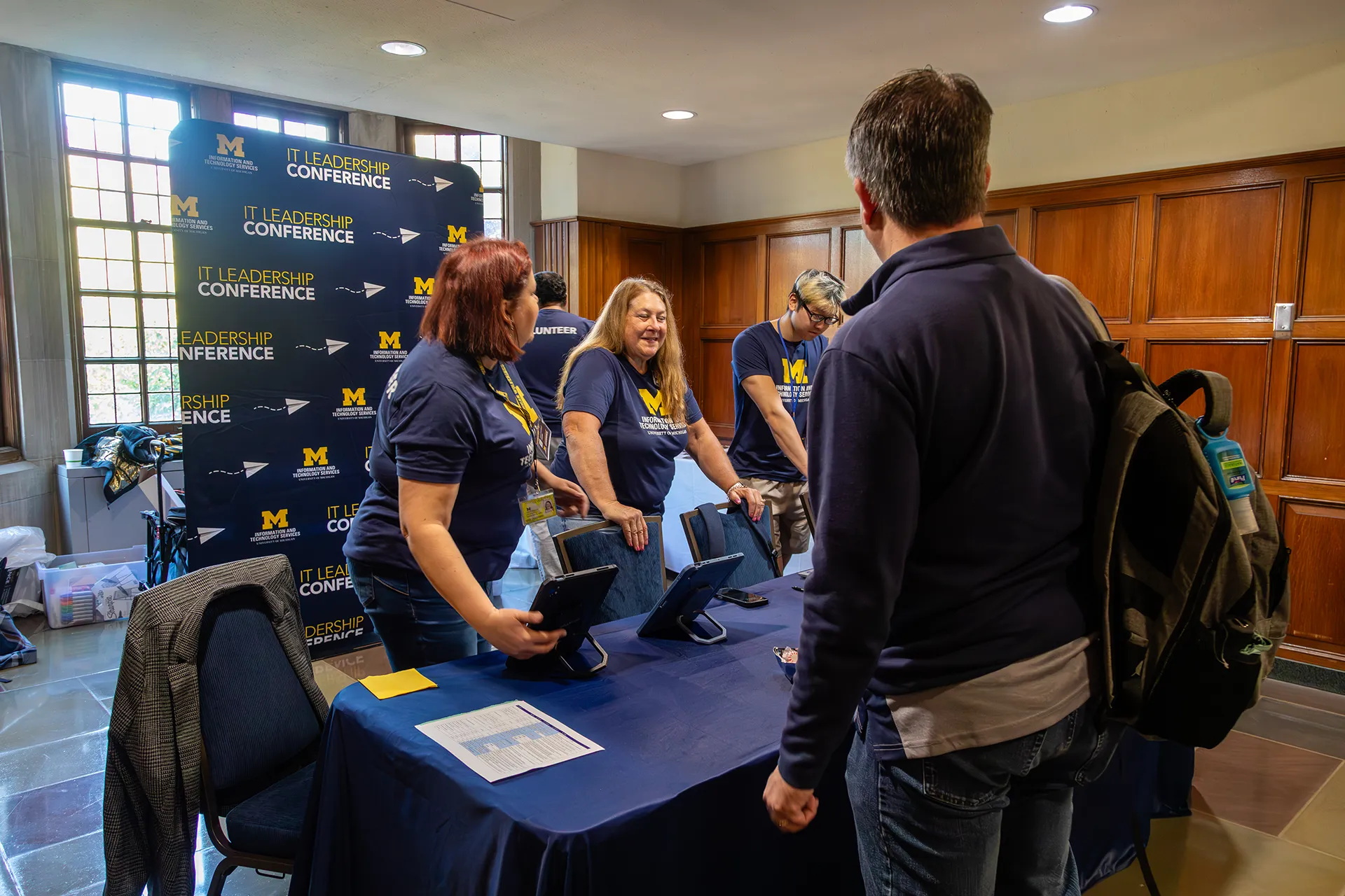 Conference volunteers behind the registration table welcoming attendees